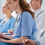 Nurse writing on clipboard